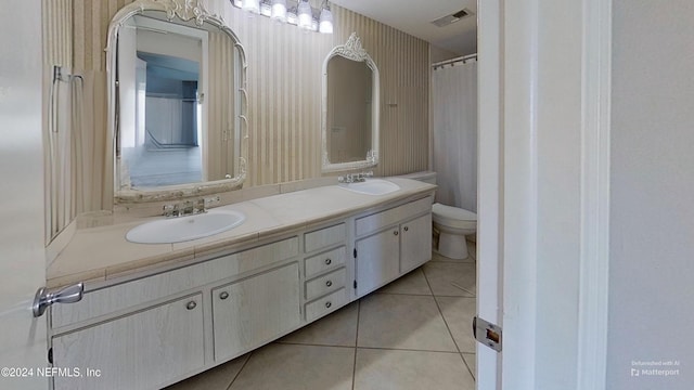 bathroom with tile patterned flooring, vanity, and toilet