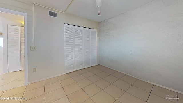 unfurnished bedroom featuring a closet and light tile patterned floors