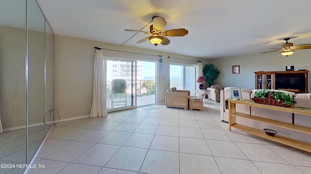 living area with ceiling fan and light tile patterned floors