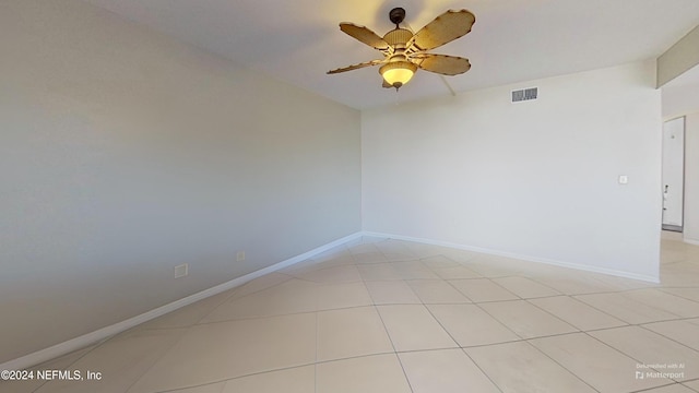 tiled spare room with ceiling fan