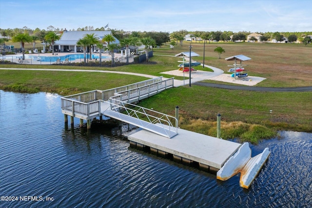 view of dock featuring a lawn and a water view