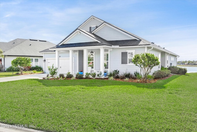 view of front of house with a front lawn, covered porch, and a garage