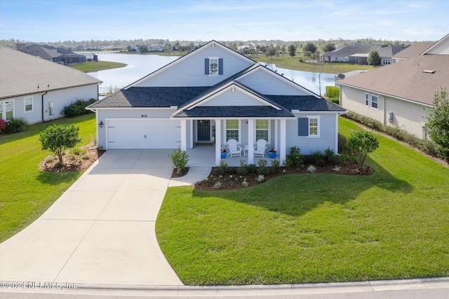 view of front of home with a porch, a water view, a front yard, and a garage