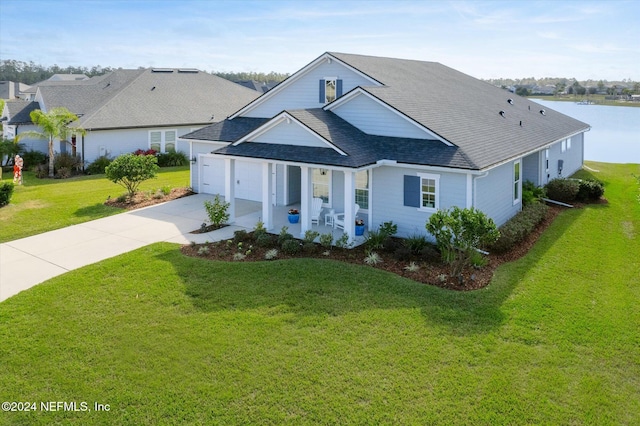 view of front of property with a front yard, a water view, and a garage