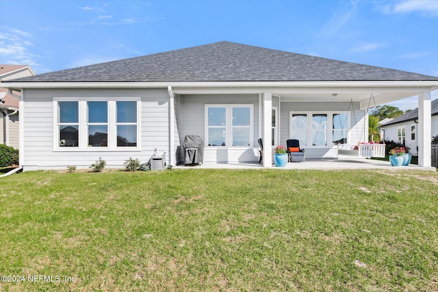 rear view of property with a lawn