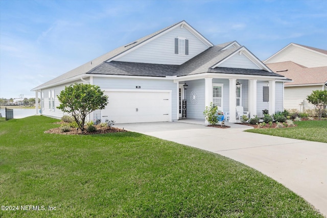 view of front of house featuring a porch, a garage, and a front lawn