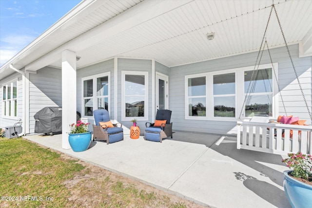 view of patio / terrace with a porch and a grill