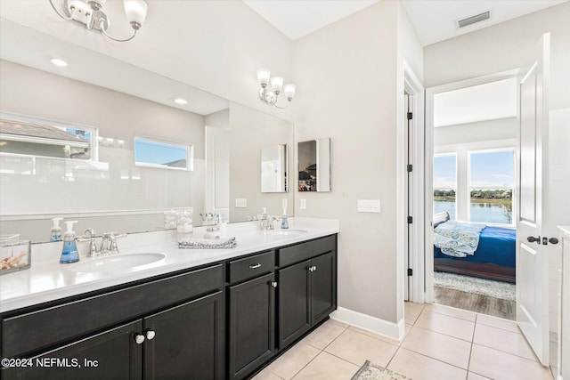 bathroom featuring tile patterned floors, vanity, a water view, and a healthy amount of sunlight