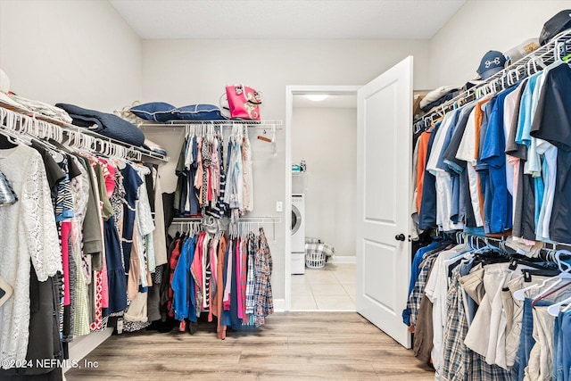 spacious closet featuring washer / dryer and light hardwood / wood-style flooring