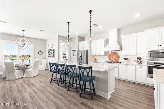 kitchen featuring appliances with stainless steel finishes, white cabinetry, and custom exhaust hood