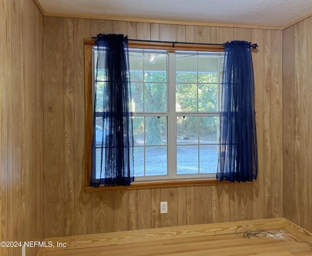 room details featuring a textured ceiling and wood walls