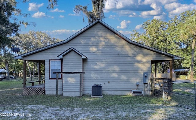 view of side of home featuring central AC and a yard