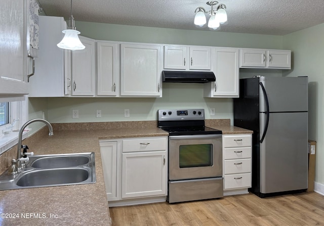 kitchen with decorative light fixtures, white cabinetry, sink, and appliances with stainless steel finishes