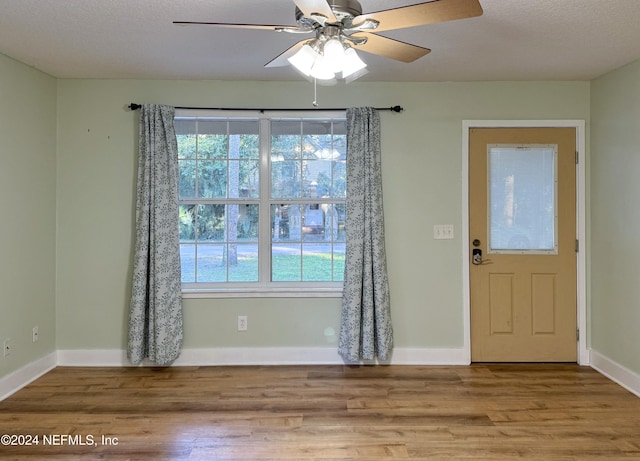 entryway featuring ceiling fan, light hardwood / wood-style floors, and a textured ceiling