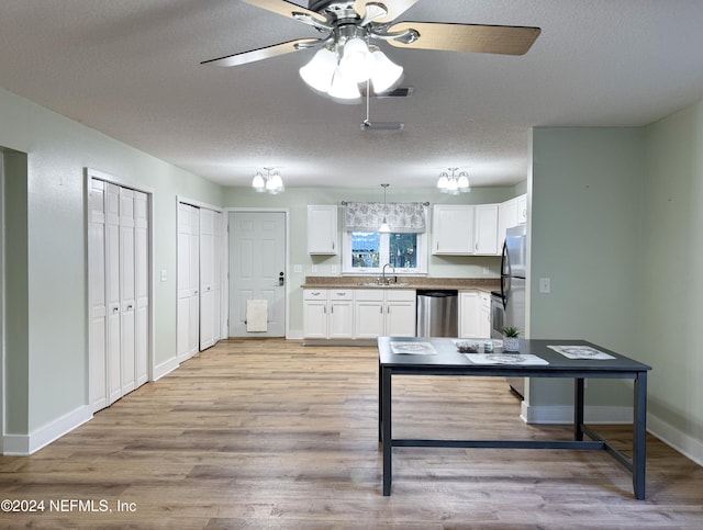 kitchen featuring light wood-type flooring, a textured ceiling, sink, dishwasher, and white cabinets