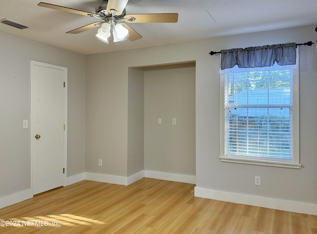 unfurnished room with ceiling fan, plenty of natural light, hardwood / wood-style floors, and a textured ceiling