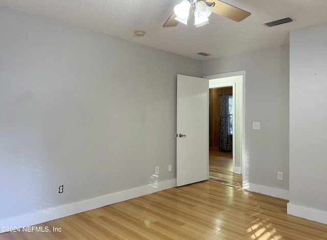 unfurnished room featuring a textured ceiling, light hardwood / wood-style floors, and ceiling fan