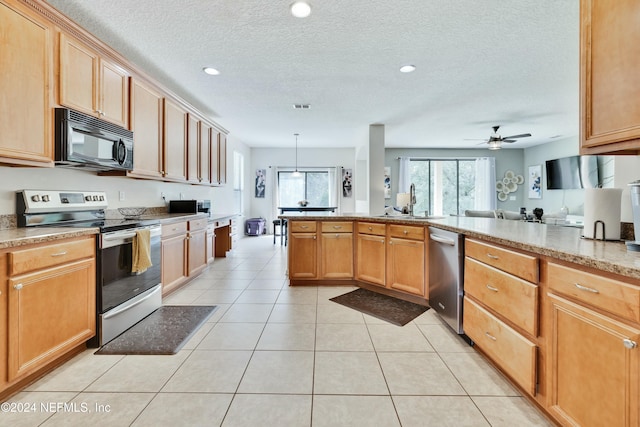 kitchen with ceiling fan, light tile patterned floors, a textured ceiling, appliances with stainless steel finishes, and decorative light fixtures