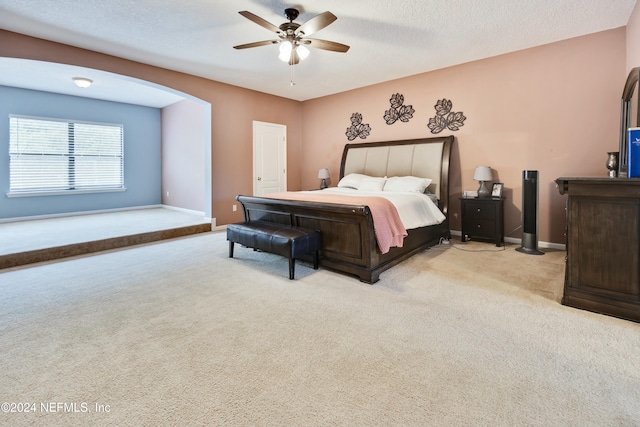 bedroom with light carpet, a textured ceiling, and ceiling fan