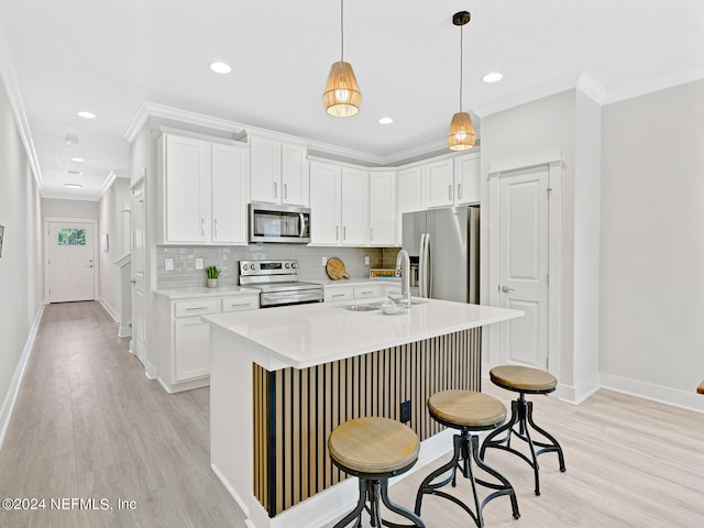 kitchen with sink, appliances with stainless steel finishes, white cabinets, and decorative light fixtures