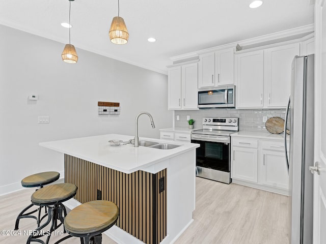 kitchen featuring white cabinetry, hanging light fixtures, stainless steel appliances, and a center island with sink