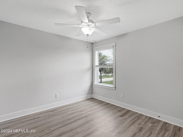 empty room featuring a textured ceiling, ceiling fan, and wood-type flooring