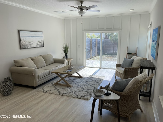 living room featuring a textured ceiling, crown molding, ceiling fan, and light hardwood / wood-style flooring