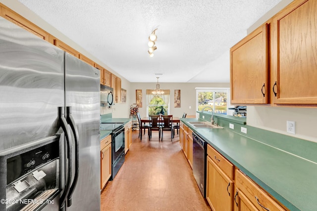 kitchen with a textured ceiling, sink, black appliances, decorative light fixtures, and light hardwood / wood-style flooring