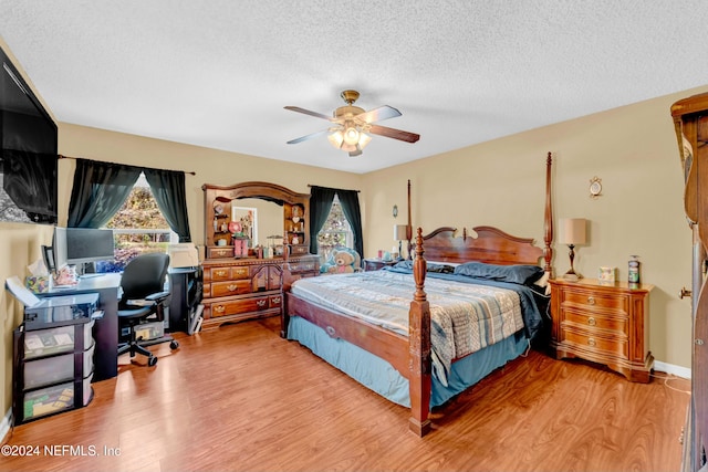 bedroom with ceiling fan, a textured ceiling, and light wood-type flooring