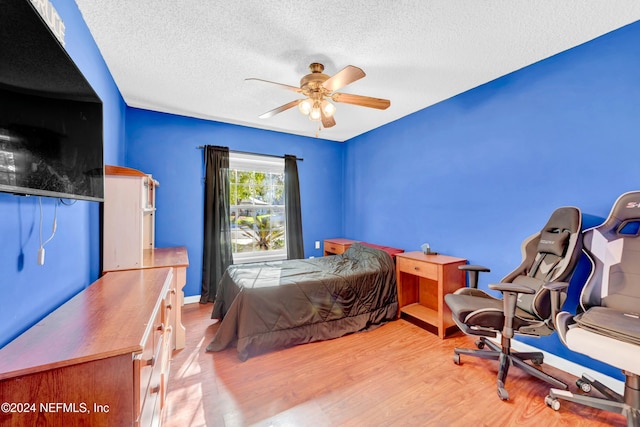 bedroom featuring a textured ceiling, light hardwood / wood-style floors, and ceiling fan