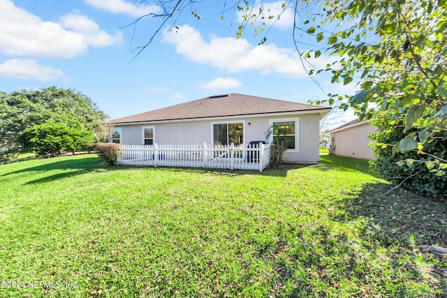 rear view of property with a lawn