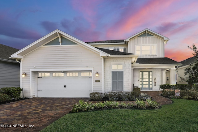 view of front of house with a yard, french doors, and a garage