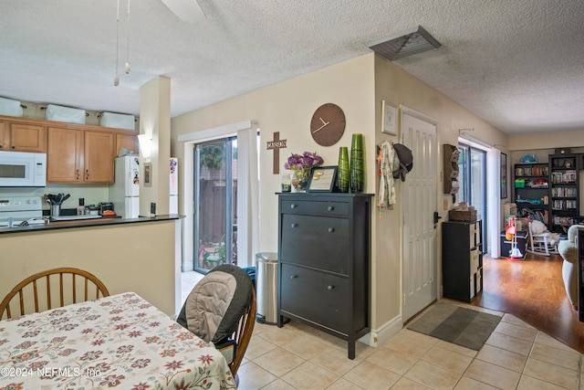 2975 SW Sunset Trace Cir Unit 2975, Palm City, FL 34990 - dining room featuring a textured ceiling, light hardwood / wood-style flooring, and a healthy amount of sunlight