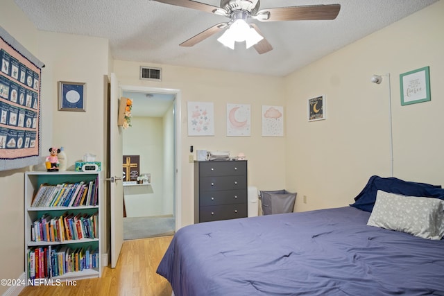 2975 SW Sunset Trace Cir Unit 2975, Palm City, FL 34990 - bedroom featuring ceiling fan, light wood-type flooring, and a textured ceiling