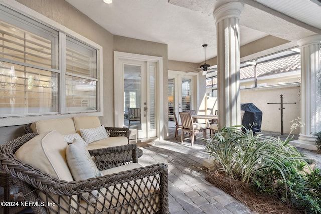 sunroom with ceiling fan and ornate columns