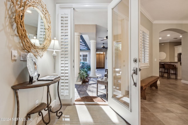 interior space with light tile patterned floors, ceiling fan, and ornamental molding