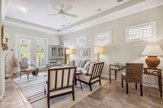 sitting room with ceiling fan, a raised ceiling, light tile patterned floors, and french doors