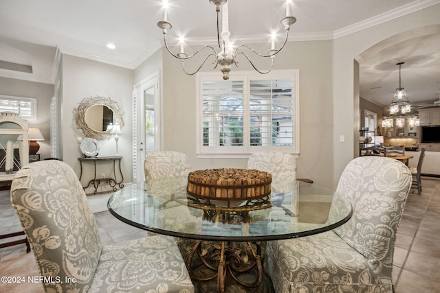 tiled dining area featuring crown molding and a chandelier