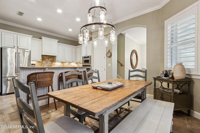 dining space featuring ornamental molding, light tile patterned floors, and a chandelier