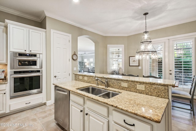 kitchen with a center island with sink, a wealth of natural light, sink, and appliances with stainless steel finishes