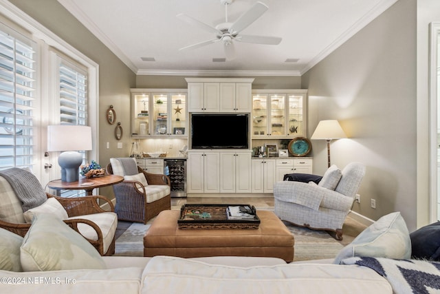 living room with light wood-type flooring, beverage cooler, crown molding, and ceiling fan