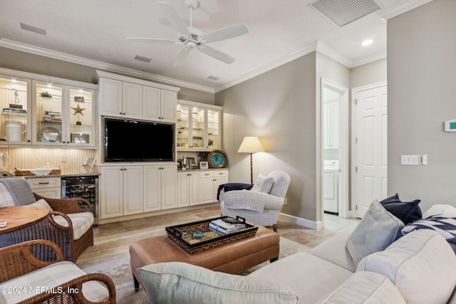 living room with washer / clothes dryer, beverage cooler, ornamental molding, and ceiling fan