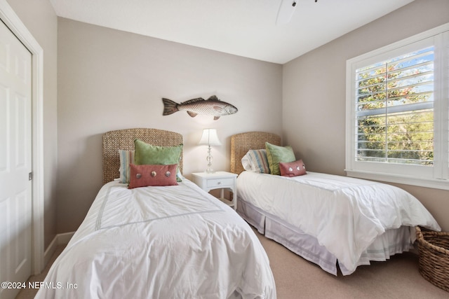 carpeted bedroom with a closet and ceiling fan