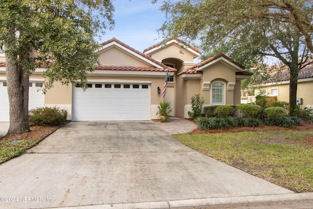 mediterranean / spanish-style house with a garage