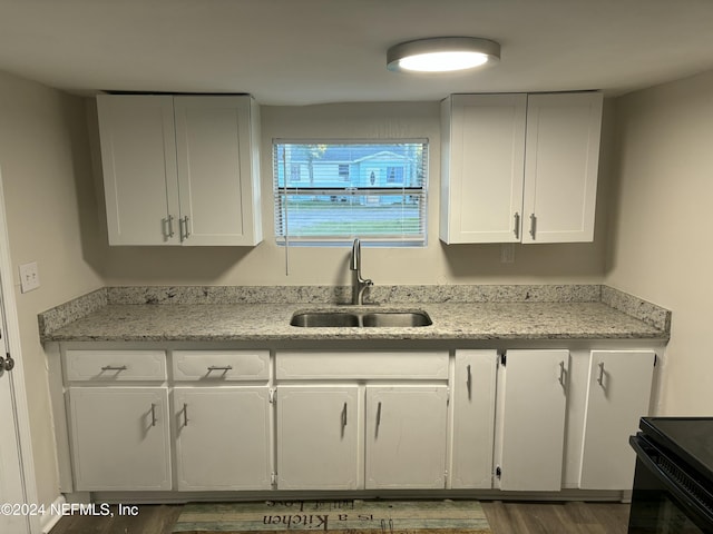 kitchen featuring sink, white cabinetry, dark hardwood / wood-style floors, black electric range, and light stone countertops