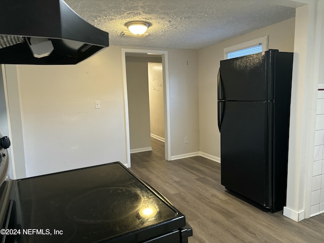 kitchen featuring range hood, hardwood / wood-style floors, a textured ceiling, and black appliances