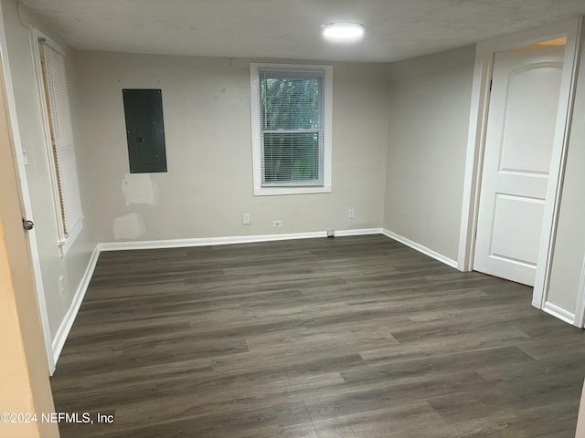 spare room with dark wood-type flooring and electric panel