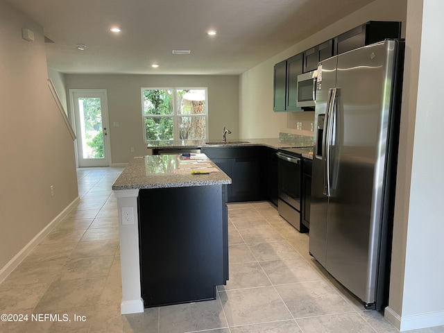 kitchen featuring sink, stainless steel appliances, light stone counters, kitchen peninsula, and light tile patterned floors