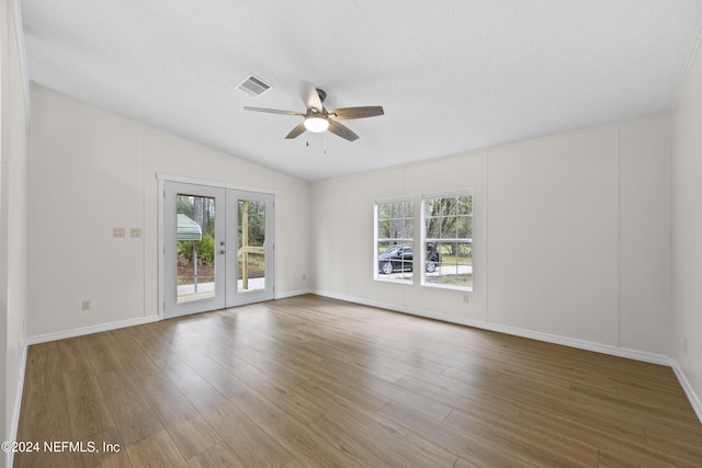 empty room with ceiling fan, french doors, hardwood / wood-style floors, and a textured ceiling