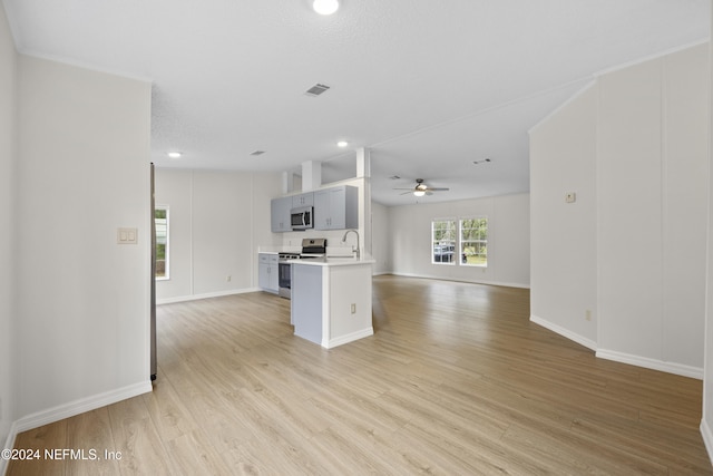 kitchen featuring ceiling fan, sink, stainless steel appliances, and light wood-type flooring